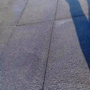 Several dark basalt pavers with a rugged, bush-hammered finish laid closely together, showing consistent charcoal tones.