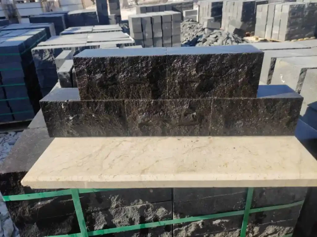 Close-up of the raw split-face texture on a basalt paving block showing natural volcanic mineral variations.