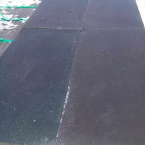 Sawn-edge black basalt slab with a smooth natural surface finish for seamless outdoor tiling.