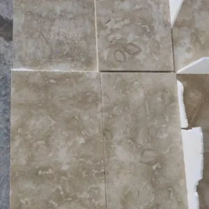 Glossy Ocean Reef limestone floor tiles on a sun-drenched covered loggia showing golden reflections.