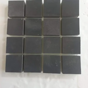 Precision-cut charcoal basalt setts with a matte sawn finish for a sleek, modern industrial driveway.