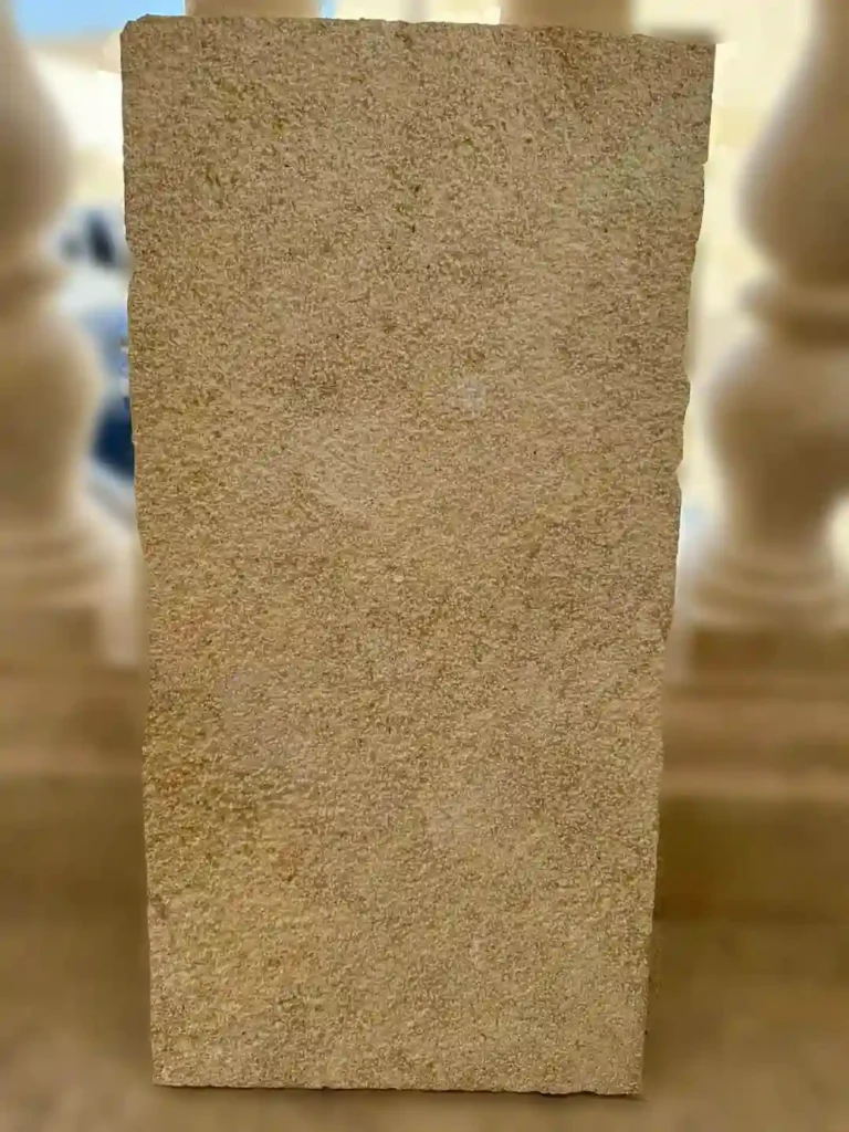 Non-slip yellow limestone tiles with an anti-slip finish installed around a luxury outdoor swimming pool.