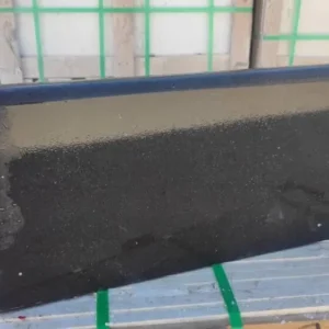 Dark basalt bullnose coping pavers with a smooth rounded edge for a luxury swimming pool surround.