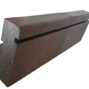 Dark charcoal basalt curbing providing a sharp, high-contrast edge between a green lawn and a gravel path.