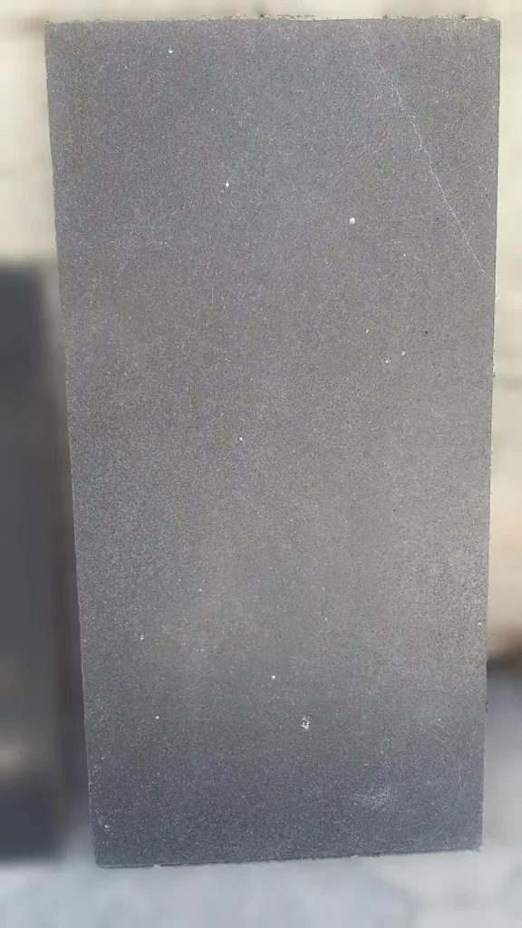 Large format black basalt slabs with a natural sawn finish for seamless modern flooring.