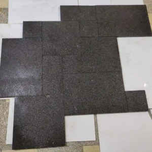 French pattern black basalt paving slabs laid in a modern grid pattern for a sleek, contemporary outdoor patio.