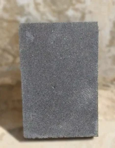 Close-up detail of natural sawn basalt texture showing subtle diamond-blade striations and volcanic mineral highlights