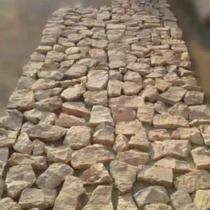 Natural limestone cobbles in random sizes showing a variety of rectangular and square shapes for rustic paving.