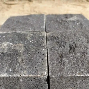 Hand-split dark basalt cobblestones arranged in a traditional fan pattern for a classic stone courtyard.