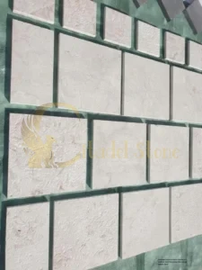 Intricate French pattern layout of various sized limestone tiles on an indoor floor