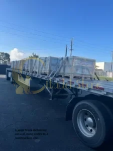 A large truck delivering natural stone crates to a construction site.