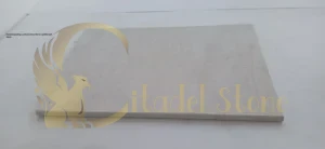 Hand inspecting a natural stone tile for quality and finish