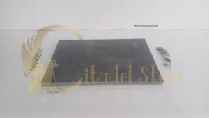 Worker in safety gear laying basalt pavers