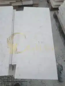 Close-up of a white paver with visible texture and beading water