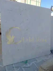 Large, polished slabs of White Pearl stone in a storage facility
