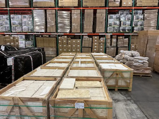 Organized warehouse facility storing natural stone materials in protective wooden crates on industrial shelving units