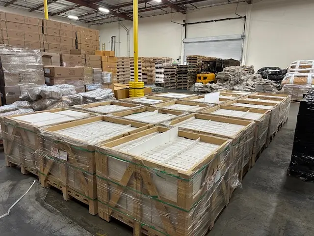 Indoor facility storing palletized stone pavers Arizona inventory in protective wooden crates on shelving