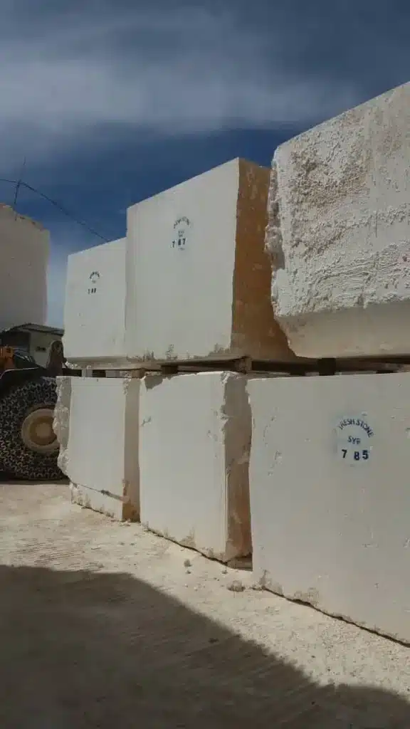 Active limestone quarry showing the massive supply of white limestone blocks available for order.