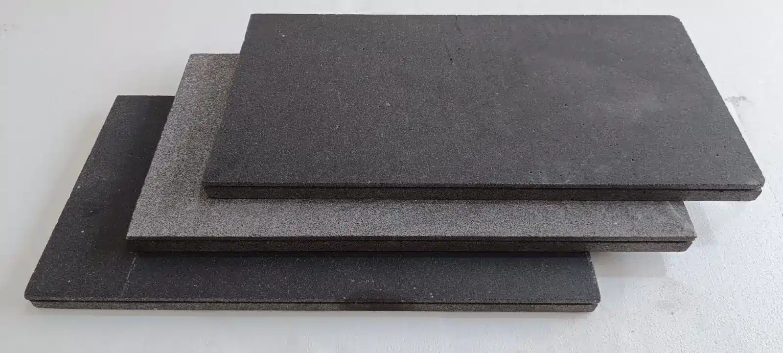 Three stacked encaustic stone tile samples exhibiting varying textures in Scottsdale.