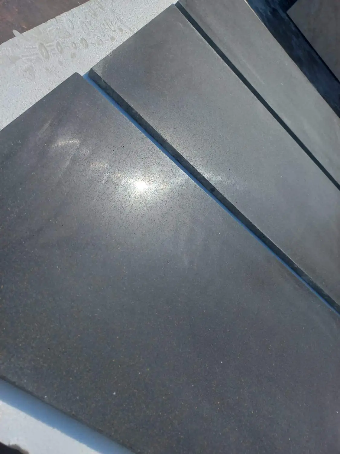 Close-up view of dark gray stone slabs arranged side by side.