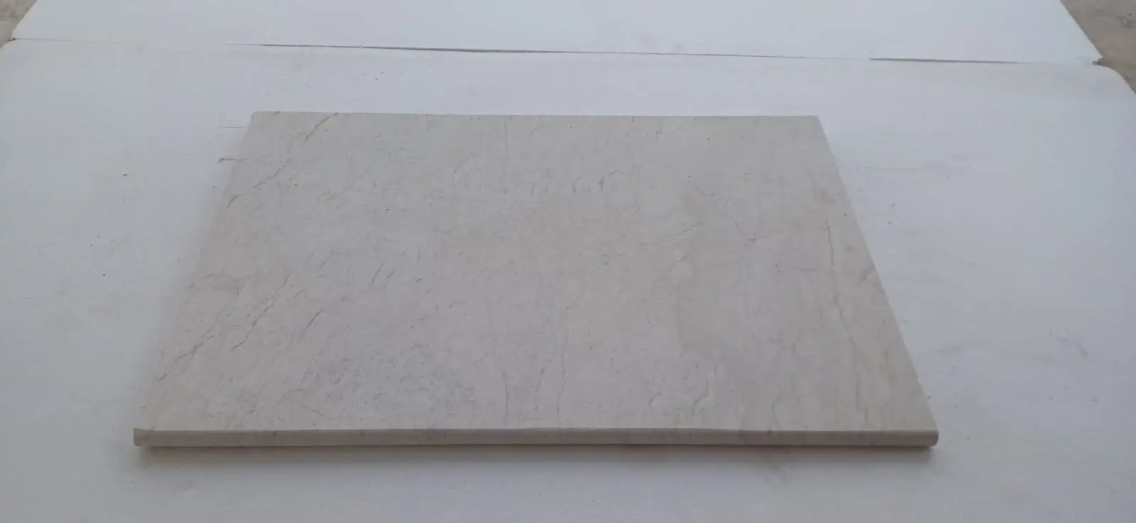 A single rectangular slab of light beige marble with subtle veining.