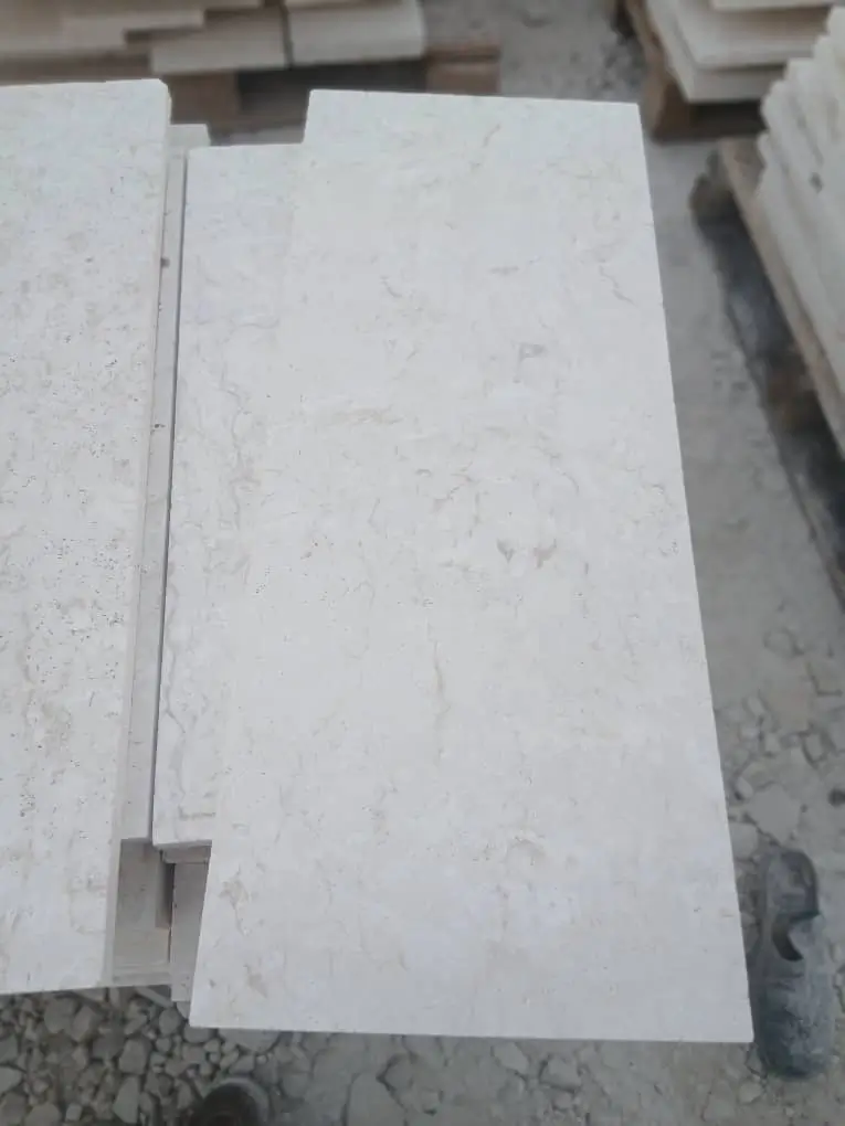 Close-up of light beige limestone slabs with subtle veining.