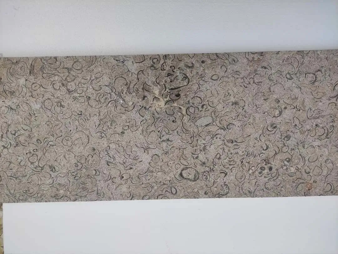 Natural Stone Texture with Swirling Patterns Detailed view of a textured limestone surface with random patterns.