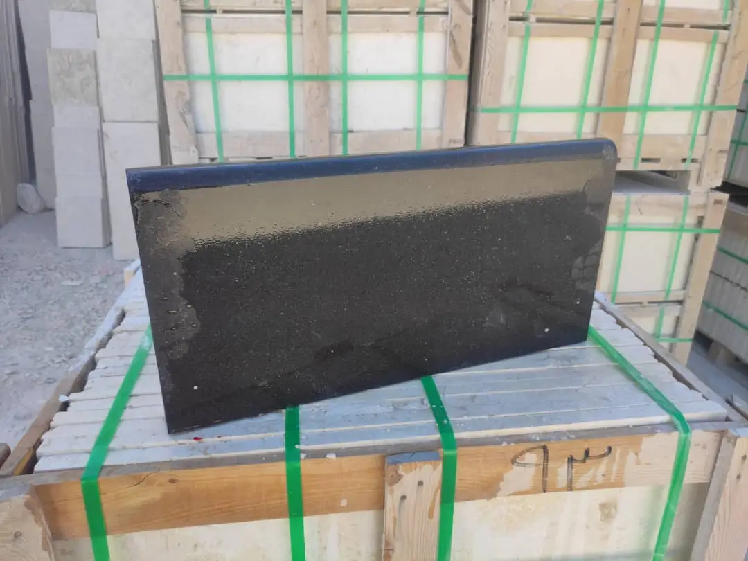 Close-up view of a dark granite countertop slab with a beveled edge.