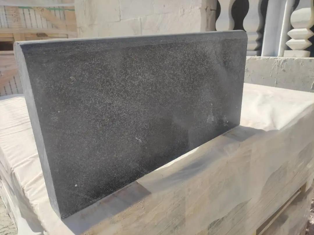 Dark Stone Slab Edge Detail Close-up of a dark gray granite slab with a beveled edge.