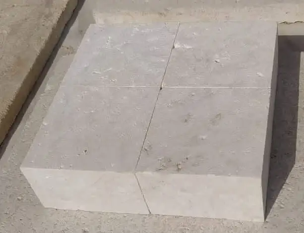 Close-up view of four light-colored limestone blocks forming a larger rectangular shape.