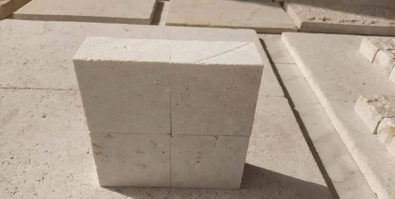 Close-up of four light beige limestone blocks arranged in a square.