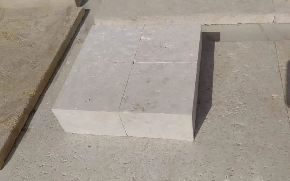 Light grey limestone pavers arranged on a granular surface, showing seams.