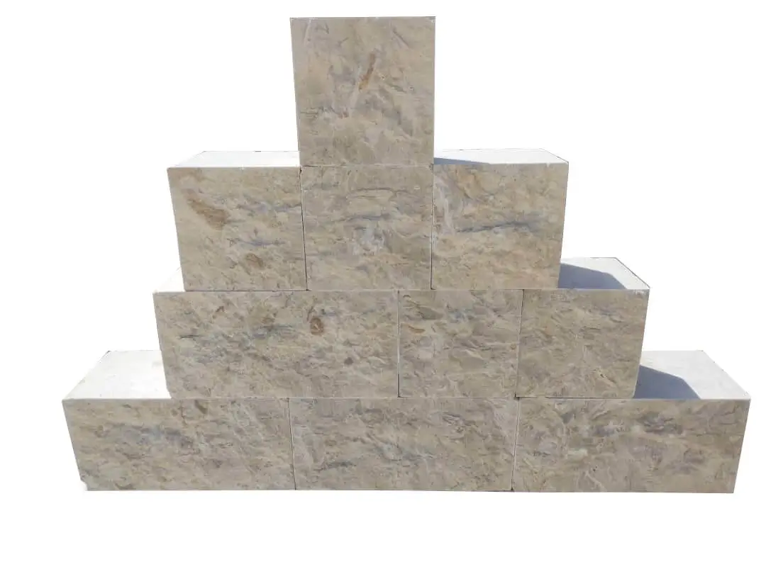 Several beige limestone blocks are stacked in a pyramid shape for display.