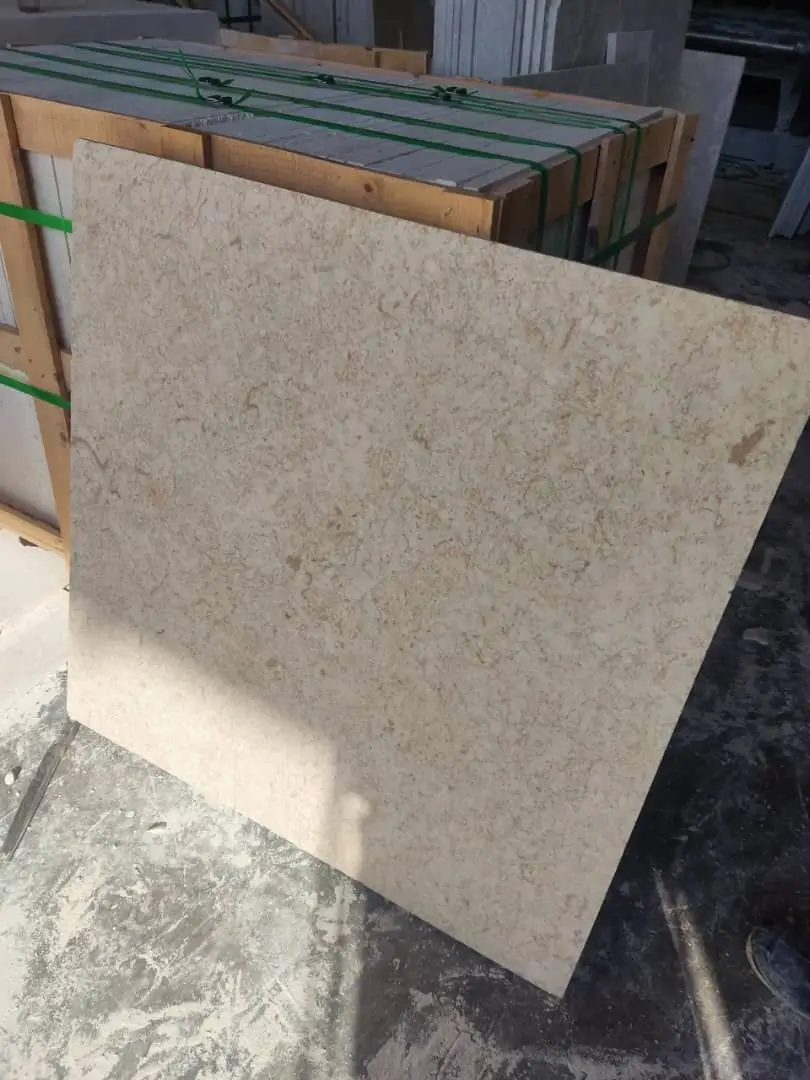 Close-up of a light beige marble slab with subtle darker veining, showcasing natural stone beauty, shown for how to fix pool tile.
