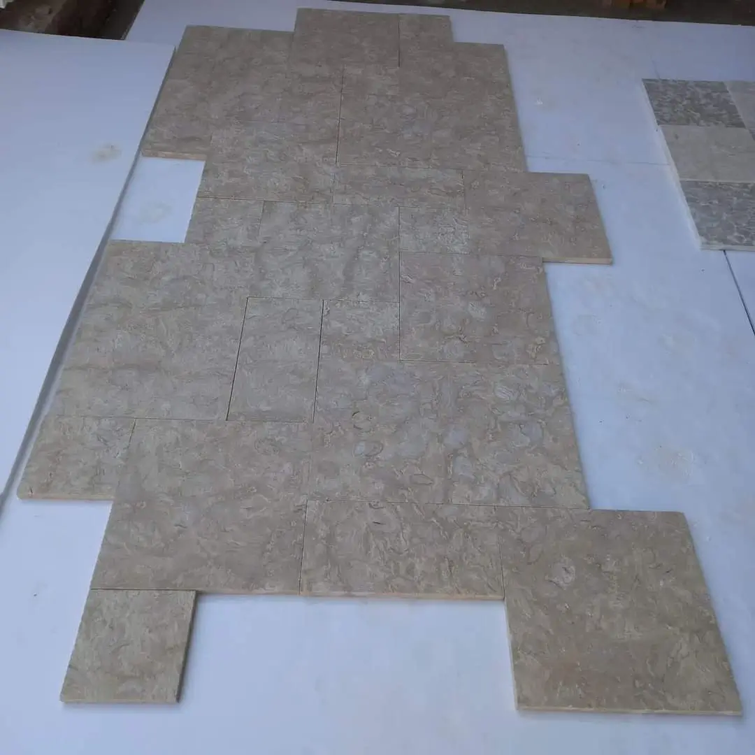 Light Beige Stone Tiles Laid Out Patterned arrangement of light beige travertine tiles laid on a white surface, relevant to how to clean a limestone patio.