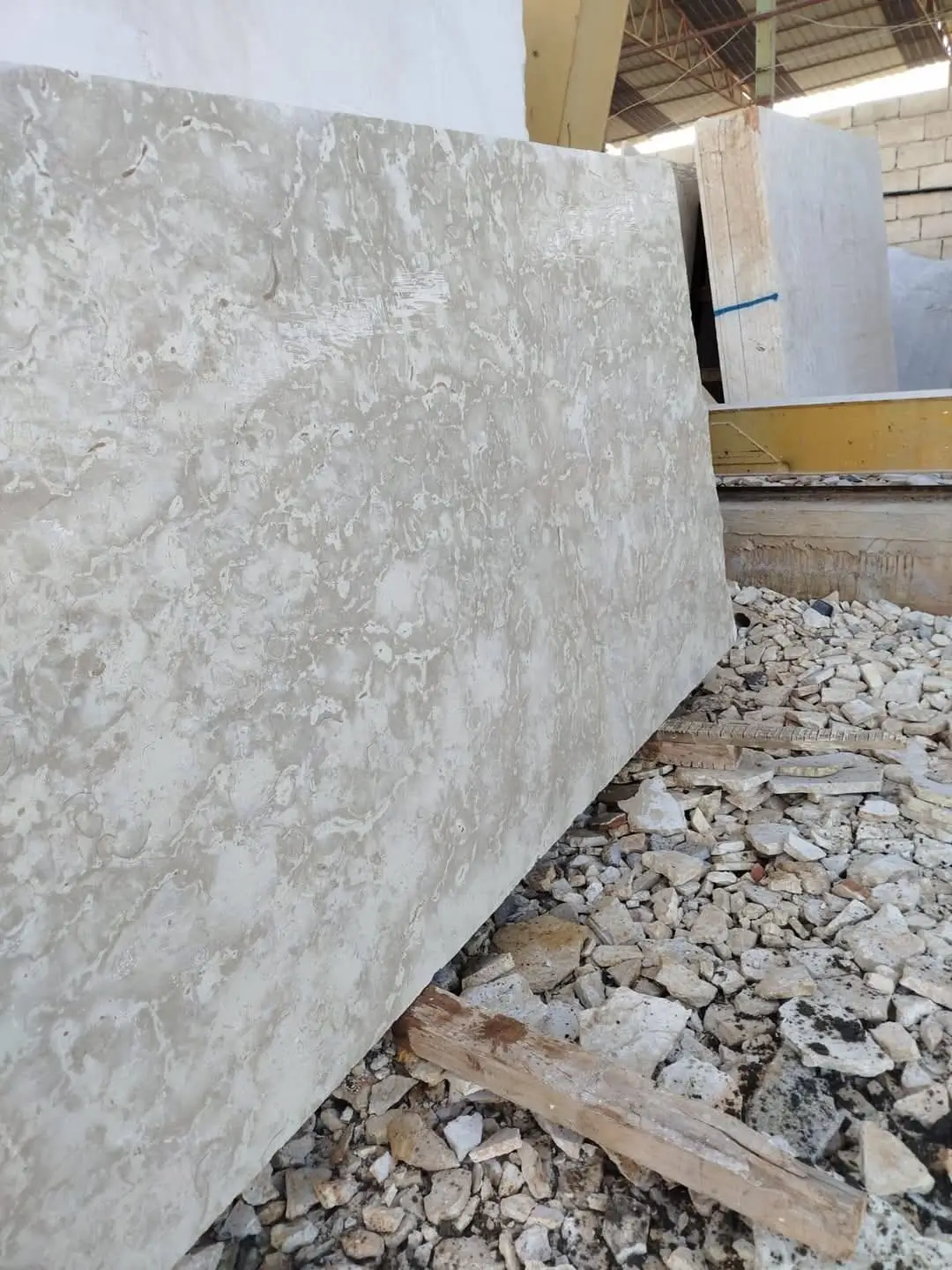 Light colored stone slab with texture Close-up of a light-colored travertine slab with natural veining patterns, a reference for how to clean a limestone patio.