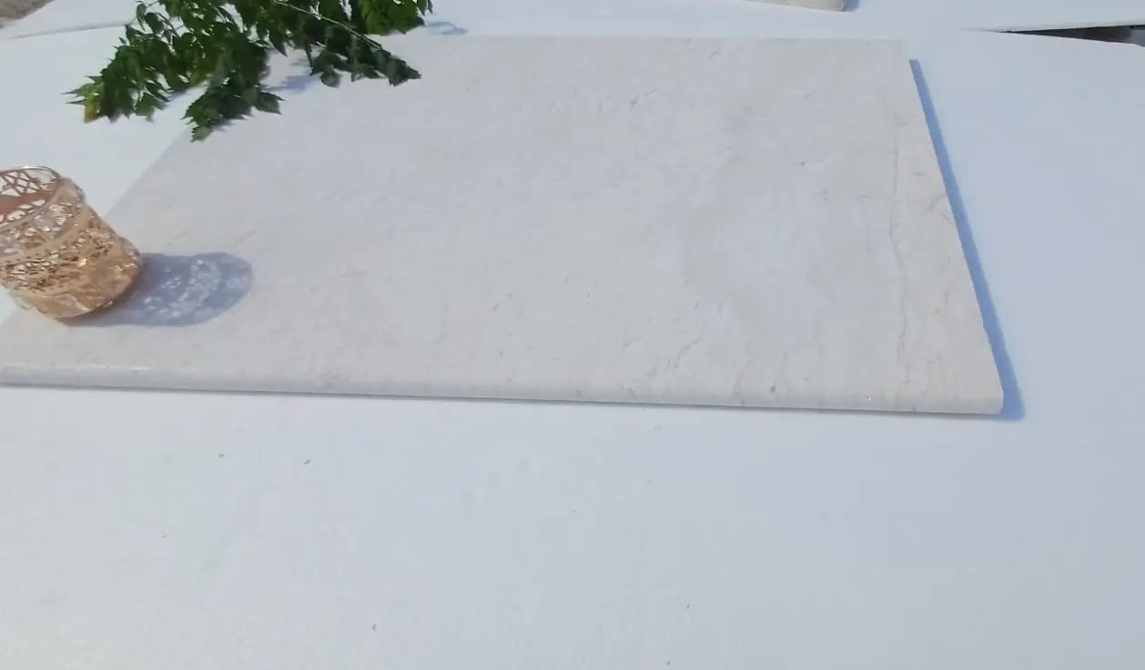 Close-up texture of light marble slabs with veining and a decorative holder, shown for how to build dry stone wall.
