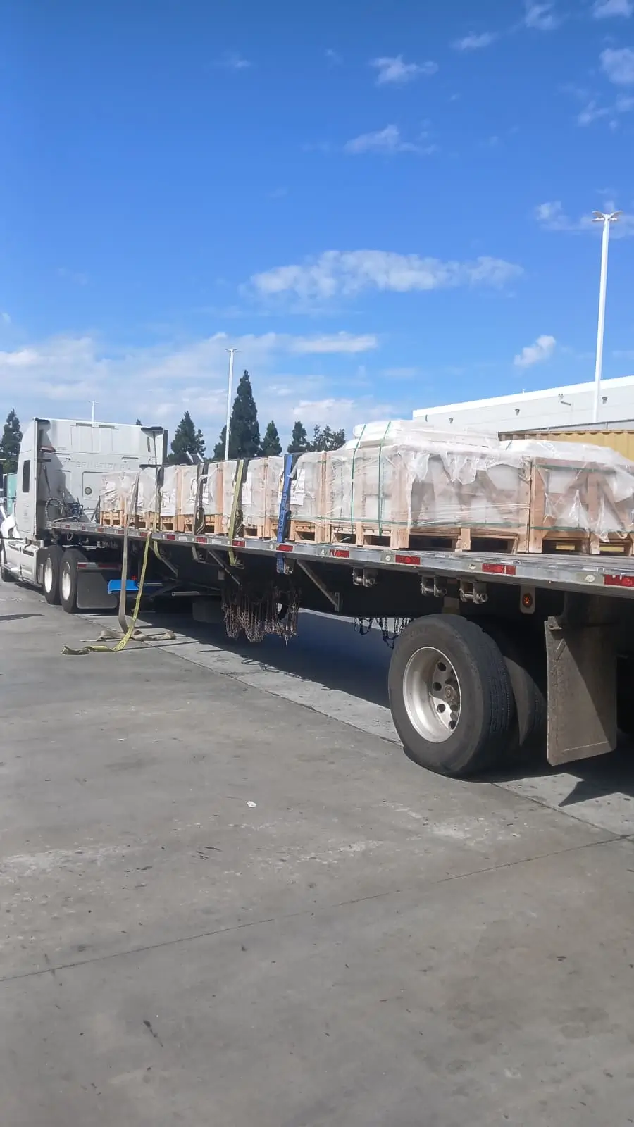 Natural-Stone-Delivery-Truck-Loaded-Crates Delivery truck loaded with natural stone crates for landscaping rock bulk cost applications.