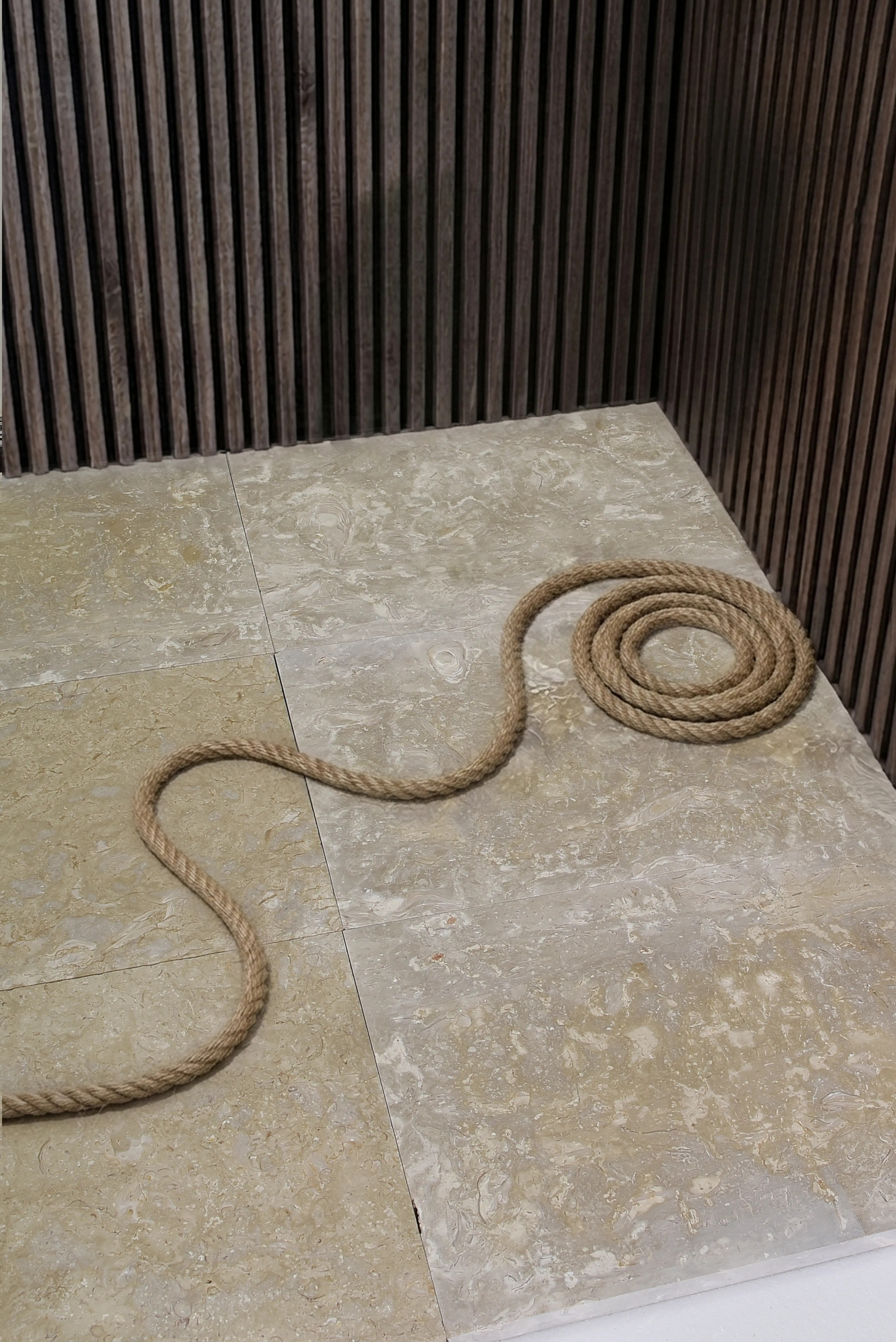 Natural beige limestone floor tiles with a coiled jute rope, shown for rubble masonry explained.