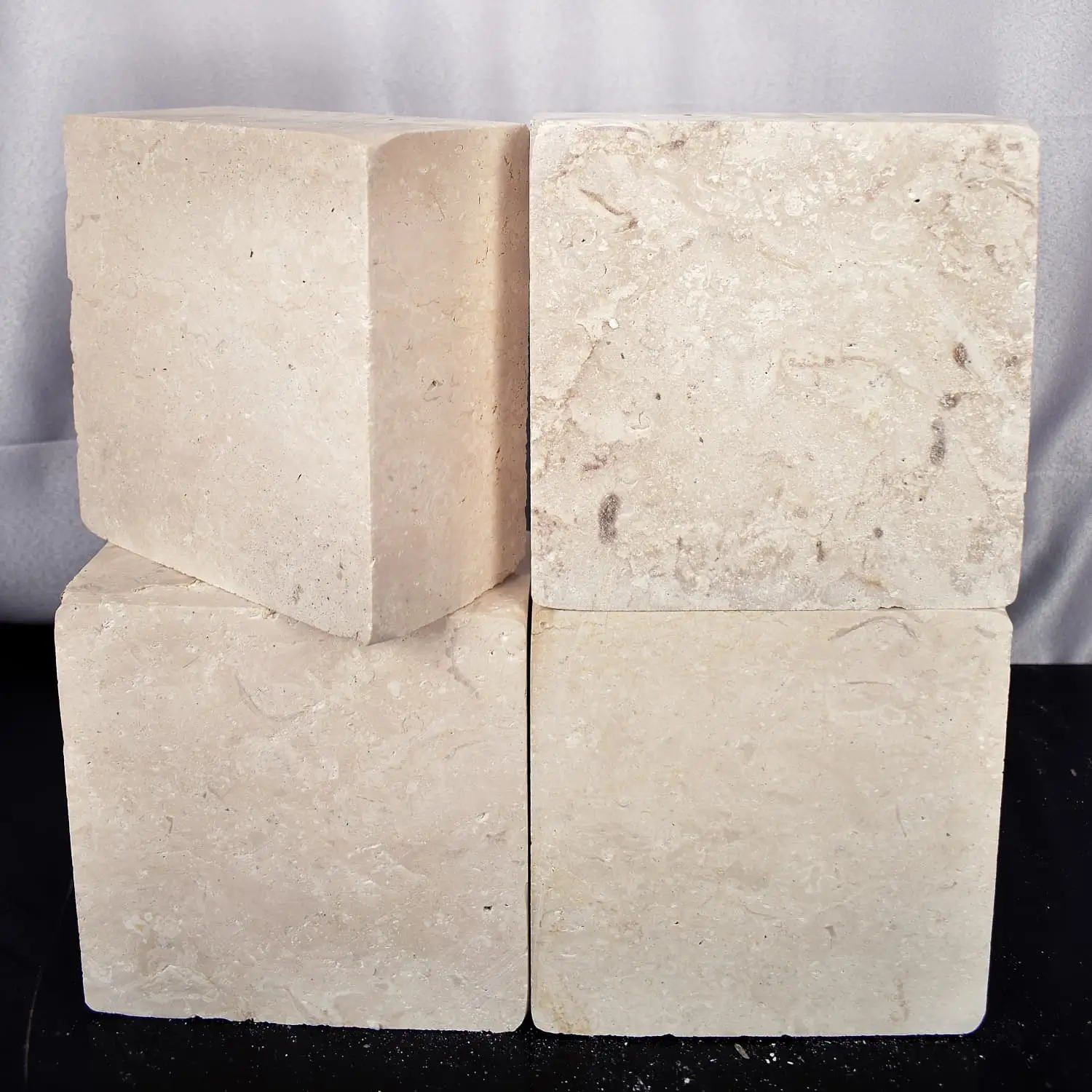Four cream-colored natural stone blocks stacked in a stable formation for landscaping, shown for rectangle stone pavers.