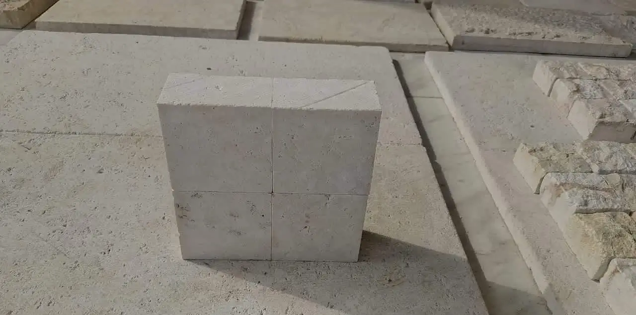 Stacked beige limestone blocks show a rough textured surface with visible pores and veins, relevant to yorkstone paver.