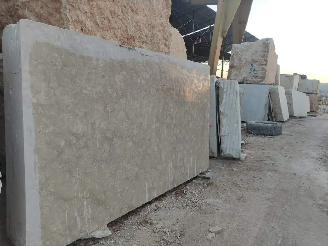 Stacked Natural Stone Slabs Outdoors Large slabs of textured limestone are stacked and displayed in an outdoor yard setting, pictured for Limestone Driveway Pavers.