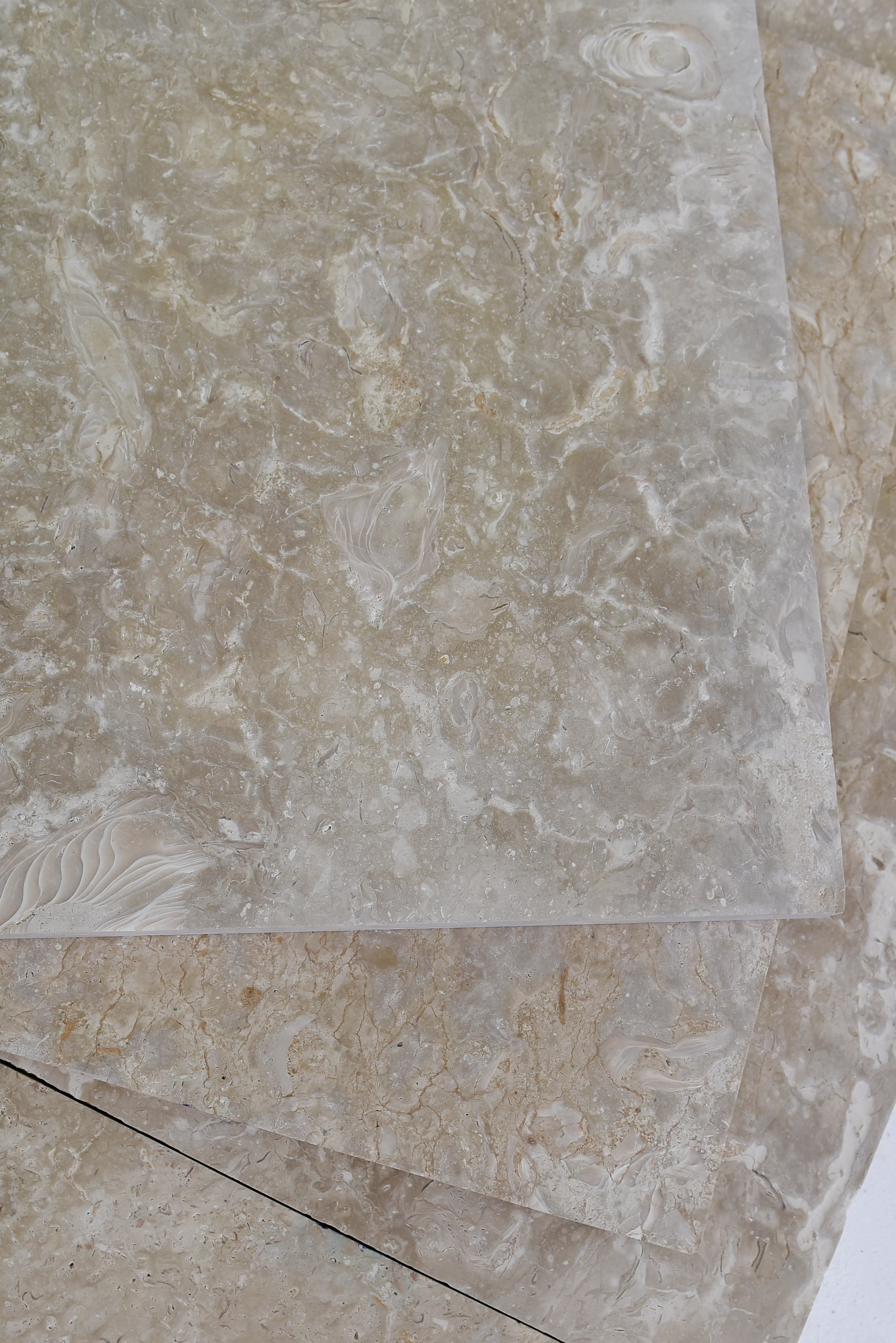 Textured Beige Marble Stone Slabs Close-up view of beige travertine tiles showcasing intricate fossil patterns, a reference for flagstone patio installation cost.