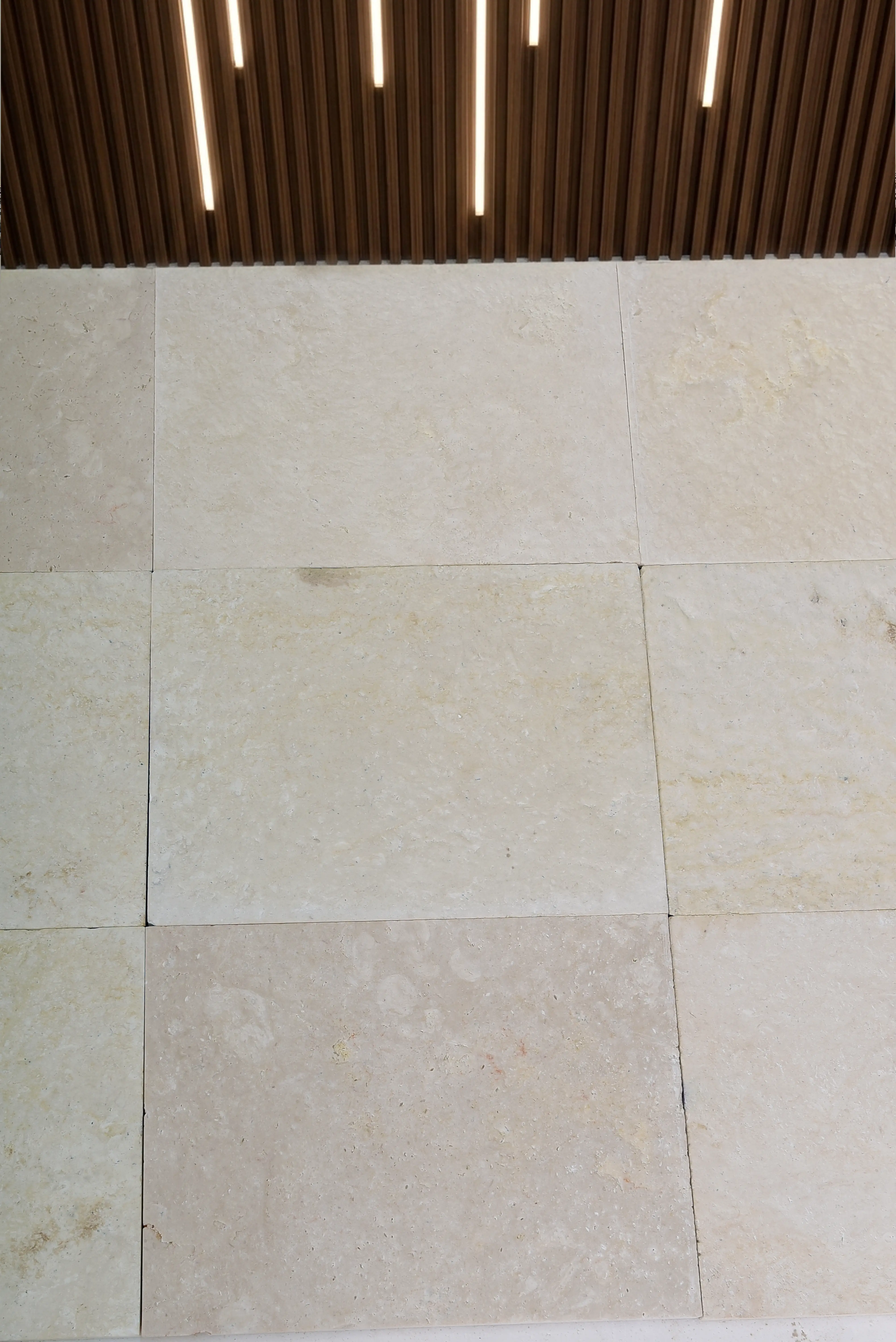 Close-up of light beige limestone pavers showcasing natural texture and subtle color variations, a reference for white travertine marble.