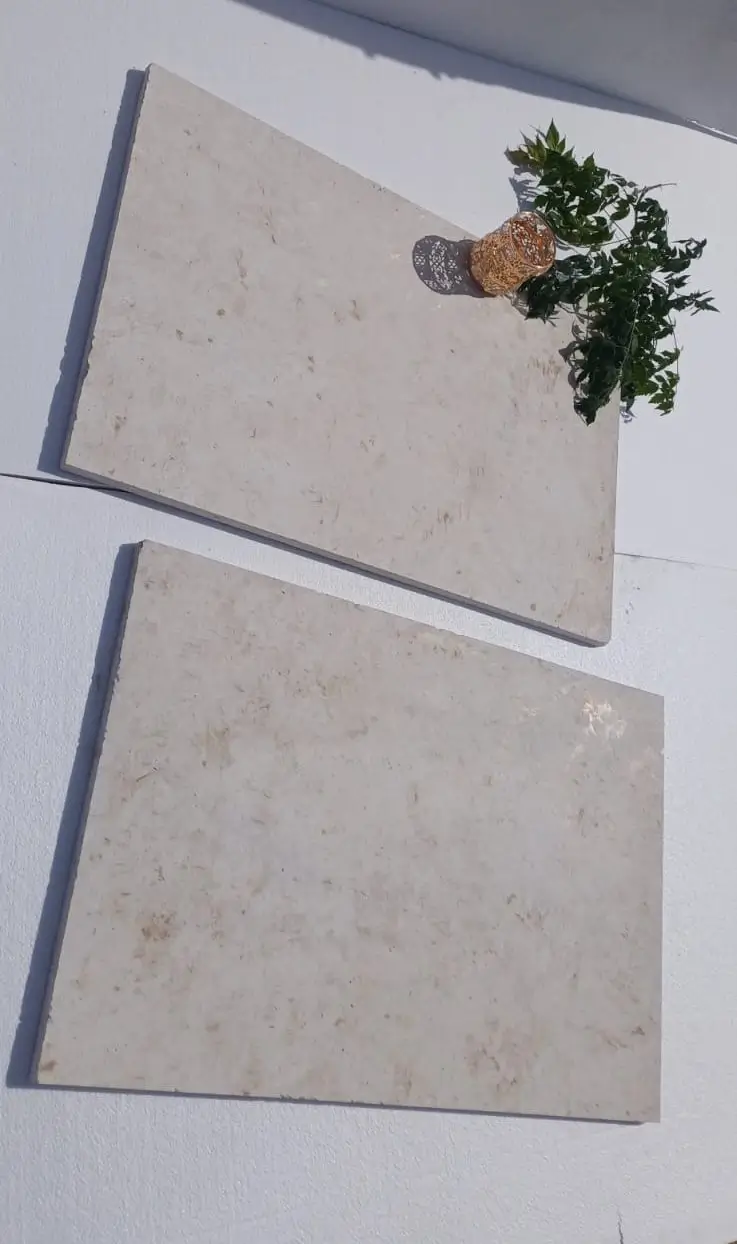 Light beige limestone slabs with subtle marbling detail in natural sunlight, pictured for why edging stones keep shifting.