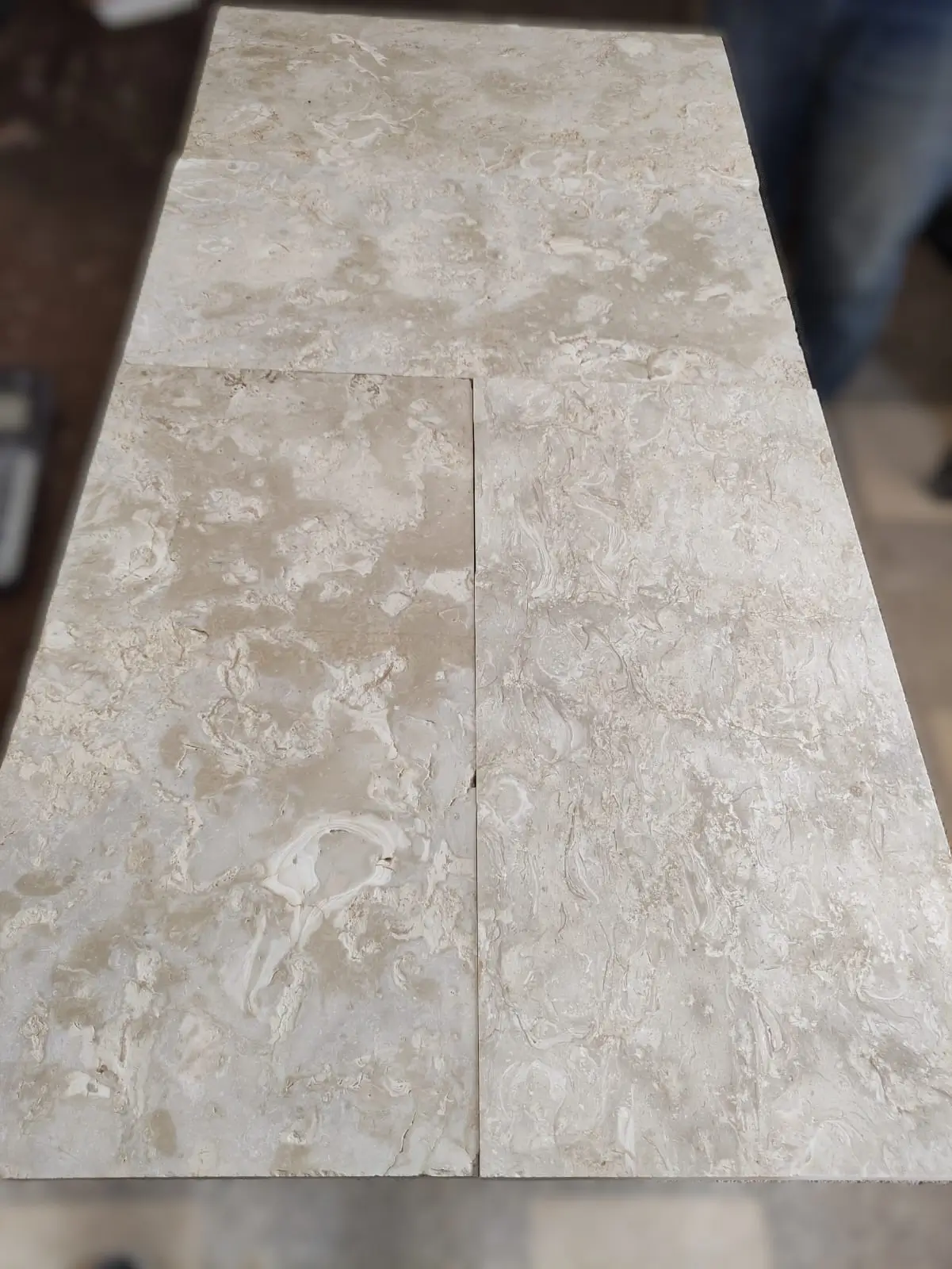 Close-up of beige marble tiles showcasing intricate veining and natural patterns, an example for landscaping wall stone.