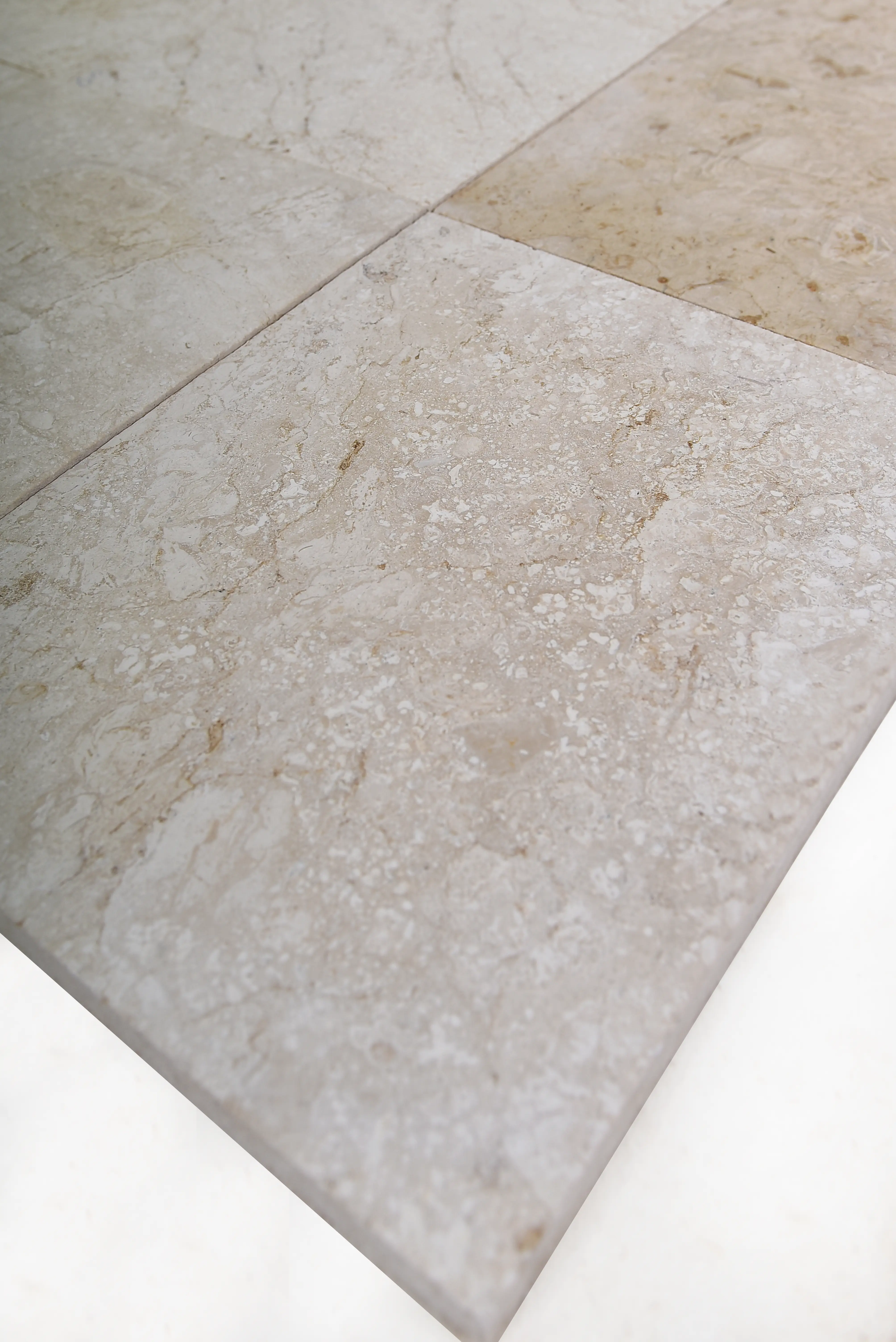 Close-up of beige marble tile with intricate veining for a luxurious flooring material, an example for pavers for garden beds.