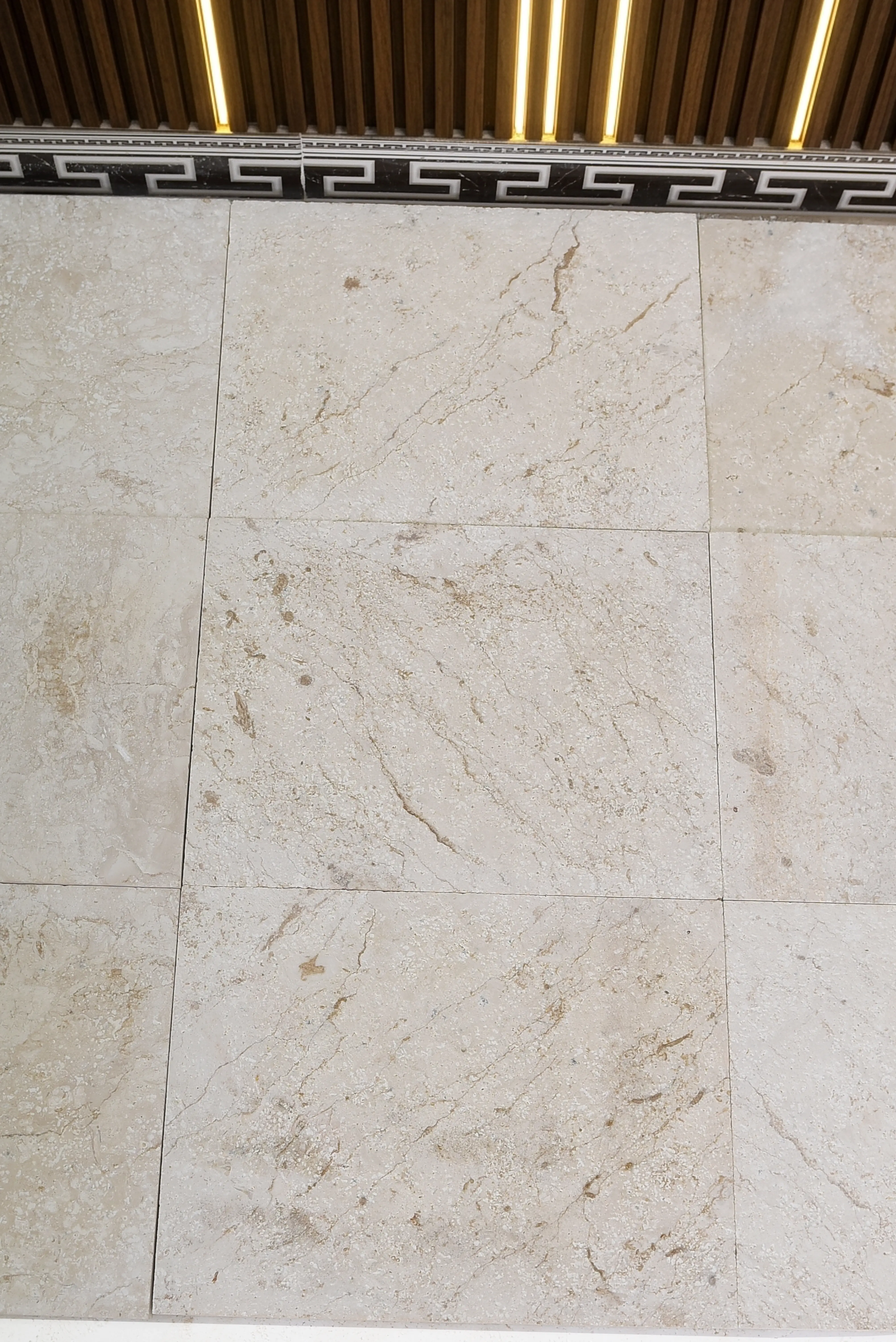 Beige Marble Tile Wall Texture Close-up surface of beige marble tile wall showing natural veining patterns, a reference for granite countertop cost breakdown.