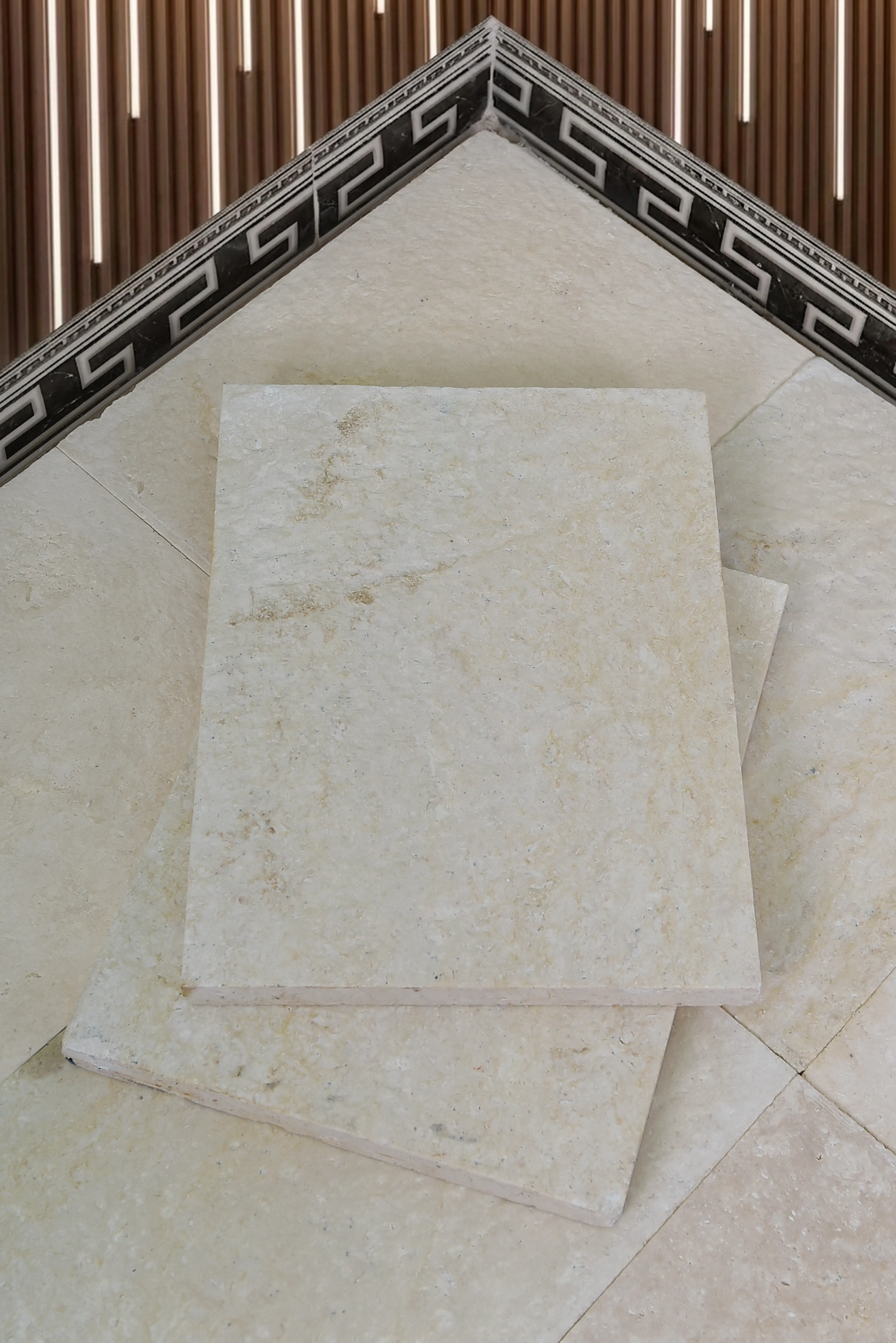 Close-up view of stacked beige marble tiles showcasing natural veining and texture, pictured for Kerb Stones & Edging.