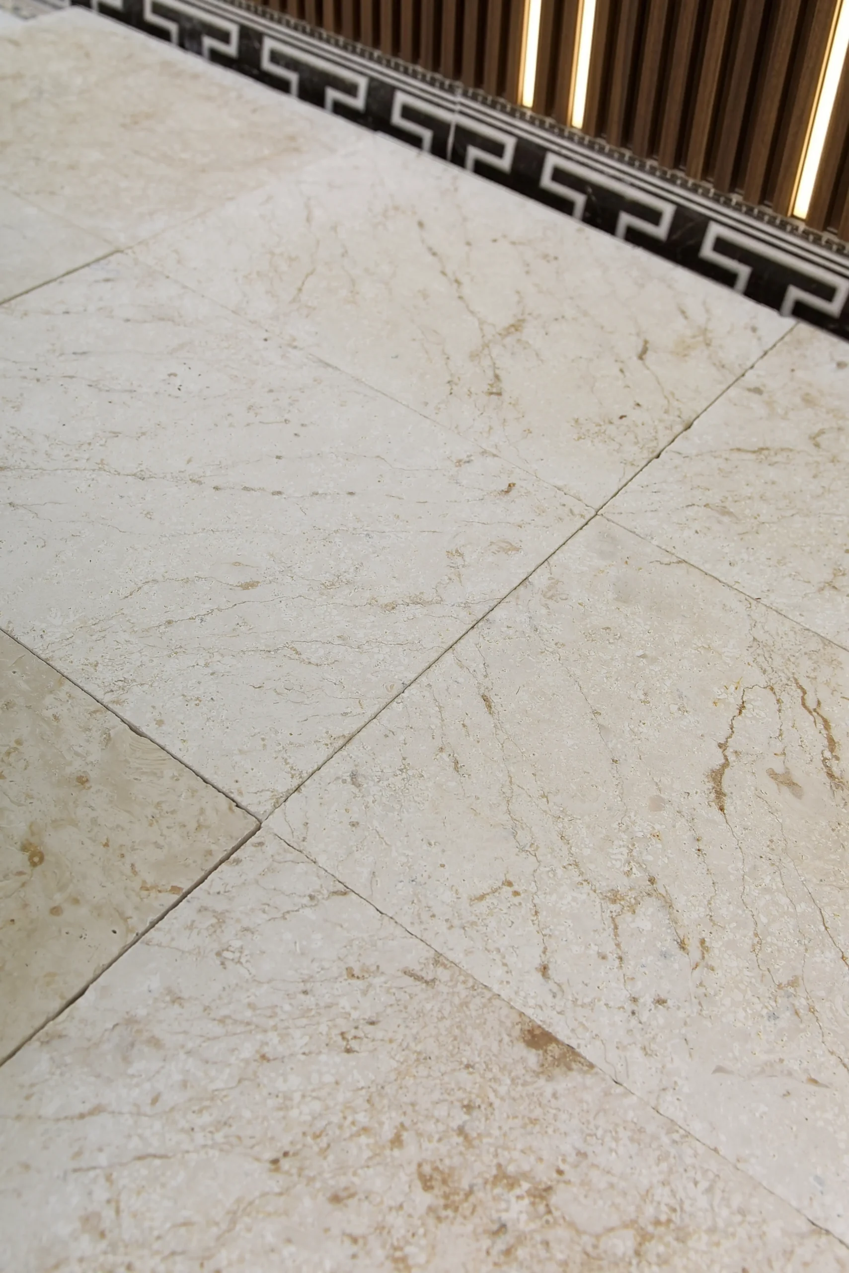 Beige travertine floor tiles laid across an interior floor, shown for 24x24 travertine tile.
